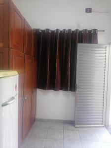 cocina con puerta y ventana en una habitación en quarto para Rapaz, centro, Sinop MT, en Sinop