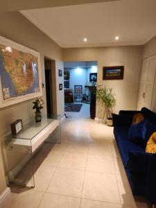 a living room with a blue couch and a table at Jenvey House Selfcatering Apartments & BnB in Port Elizabeth