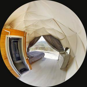 duży namiot z łóżkiem i telewizorem w obiekcie 4 seasons. 4 სეზონი Glamping Georgia Racha w mieście Ambrolauri