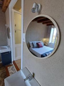 a bathroom with a mirror over a sink and a bed at FeelhomeVIC. Ático con terraza en centro histórico in Vic