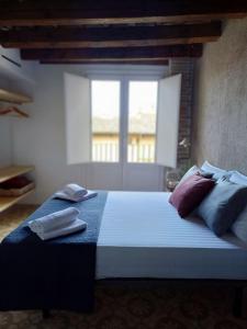 1 dormitorio con cama con almohadas y ventana en FeelhomeVIC. Ático con terraza en centro histórico en Vic