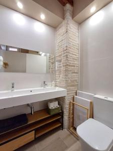 a bathroom with a white sink and a toilet at FeelhomeVIC. Ático con terraza en centro histórico in Vic