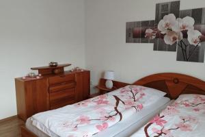 Un dormitorio con una cama y un tocador con flores. en Ferienwohnung Schmidt, en Airlenbach
