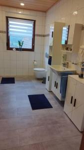 La salle de bains est pourvue de toilettes, d'un lavabo et d'une fenêtre. dans l'établissement Ferienwohnung Schmidt, à Airlenbach