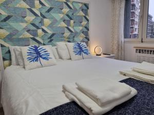 um quarto com uma cama branca e toalhas em 177A Precioso Apto en el centro de Gijón em Gijón