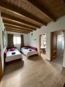 1 dormitorio con 2 camas en una habitación con techos de madera en Vallechico, en Vallebrón