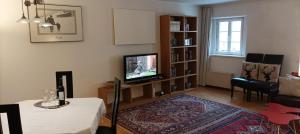 ein Wohnzimmer mit einem TV und einem Tisch mit einem Tisch in der Unterkunft Apartment Rattenberg in Rattenberg