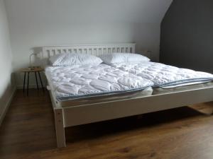 - un lit avec des draps et des oreillers blancs dans une chambre dans l'établissement Strandnahe Ostsee Ferienwohnung in Schönberg, 90m², mit Terrasse, à Schönberg in Holstein