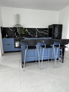 a kitchen with a blue counter with four chairs at 2-bd apartment at the heart of the Carmel in Haifa