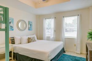 a bedroom with a white bed and two windows at Beautiful Rockport Home - Walk to Aransas Bay! in Rockport