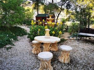 une table avec des tabourets d'arbre dans un jardin dans l'établissement Hotel La Mariposa, à Alhama de Murcia