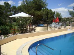 a large swimming pool with an umbrella and an umbrella at Hotel La Mariposa in Alhama de Murcia