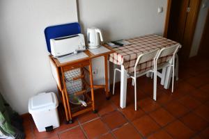 une petite table et des chaises avec une machine à coudre dans l'établissement Alojamentos Vitinho - Vila Nova Milfontes, à Vila Nova de Milfontes