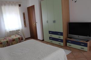 a bedroom with a bed and a tv and a dresser at Alla Stazione in Monfalcone