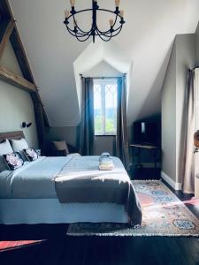 a bedroom with a large bed and a chandelier at Orpheus Lodge in Giverny