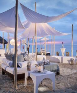un soggiorno con mobili bianchi sulla spiaggia di Windsurf Beach Front a Torre Grande
