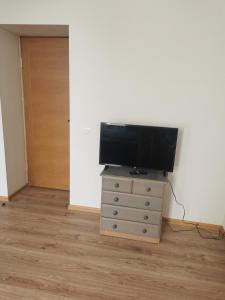 uma televisão de ecrã plano numa cómoda num quarto em Telegrafs em Ventspils