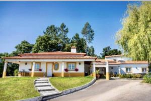 uma grande casa branca com uma entrada em Fantastic house swimmingpool jacuzzi horses em Alcobaça