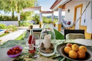 una mesa con una bandeja de fruta y copas de vino en Fantastic house swimmingpool jacuzzi horses, en Alcobaça