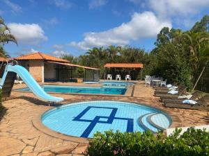 a swimming pool with a slide in a resort at Hotel Fazenda da Lagoa in Queluzita