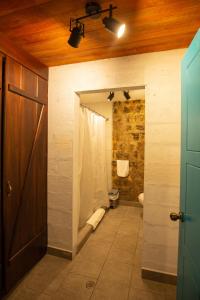 a bathroom with a shower and a toilet in it at Niebli Historical Farm and Lodge at Pululahua Volcano in Quito