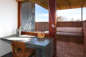 Habitación con mesa, silla y ventana en Tierra Atacama Hotel & Spa, en San Pedro de Atacama
