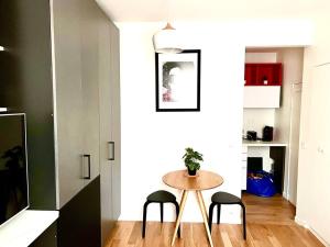 a small table in a room with two stools and a table at Deux pièces familial chic et confortable - Square Courteline - Nation - Paris centre in Paris