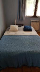 - un grand lit dans une chambre avec une couverture bleue dans l'établissement Maison 100m2, espaces verts, 8 min à pied du lac, piste cyclable, à Sévrier