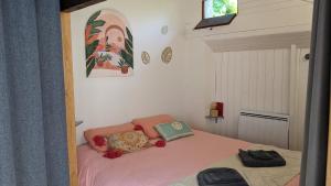 um pequeno quarto com uma cama com lençóis cor-de-rosa em Le Petit Ecrin, 80 m de la mer em Le Pouliguen