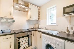 a kitchen with a washing machine and a sink at Highfield Lodge in Tring