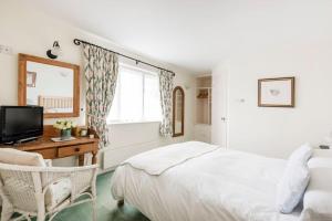 a bedroom with a bed and a desk and a television at Highfield Lodge in Tring