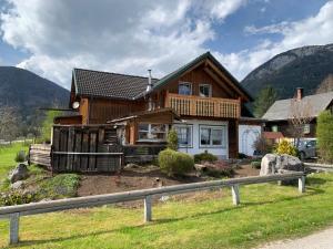 a large wooden house with mountains in the background at VillaVoigt, een Gezellig Familiehuis in Äussere Kainisch