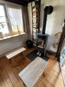 a living room with a wood stove and a bench at VillaVoigt, een Gezellig Familiehuis in Äussere Kainisch