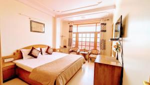 pokój hotelowy z łóżkiem i oknem w obiekcie The Thistle Lodge w mieście Shimla