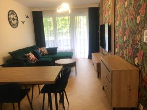 ein Wohnzimmer mit einem Sofa und einem Tisch in der Unterkunft Solankowa Aleja Apartament Egzotyczny in Inowrocław