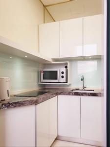 a kitchen with white cabinets and a microwave at Charming Studio 1BR 1LR Condo Georgetown 魅力一室一厅套房 in George Town