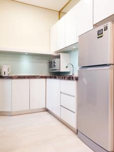 a kitchen with white cabinets and a refrigerator at Charming Studio 1BR 1LR Condo Georgetown 魅力一室一厅套房 in George Town