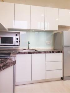 a white kitchen with white cabinets and a microwave at Charming Studio 1BR 1LR Condo Georgetown 魅力一室一厅套房 in George Town