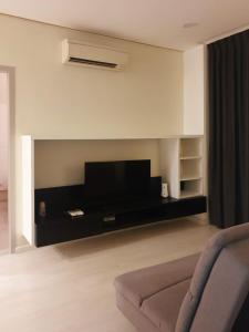 a living room with a couch and a flat screen tv at Charming Studio 1BR 1LR Condo Georgetown 魅力一室一厅套房 in George Town