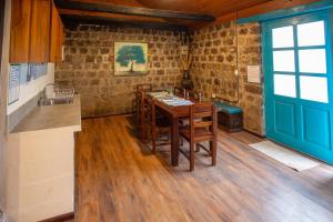 a kitchen with a wooden table and a blue door at Niebli Historical Farm and Lodge at Pululahua Volcano in Quito