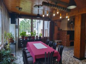 a dining room with a pink table and chairs at Къща за гости Вишнева градина in Brestnik