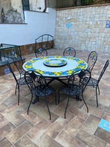 una mesa con cuatro sillas y una mesa con un plato. en CASA MARIA, en Cetara