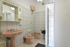 a bathroom with a sink and two toilets at Corbezzolo in Bari Sardo