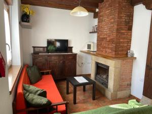 a living room with a red couch and a fireplace at La Casuca de Pumareña in Pumareña