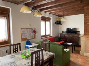 a living room with a green couch and a table at La Casuca de Pumareña in Pumareña