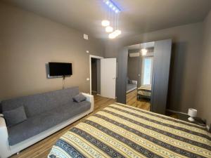 1 dormitorio con cama, sofá y TV en FrAle Rondini, en Galatina