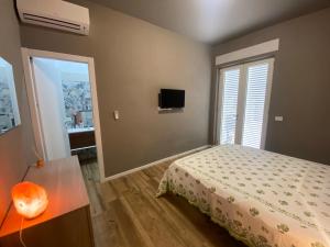 1 dormitorio con cama, espejo y TV en FrAle Rondini, en Galatina