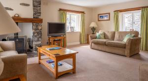 a living room with a couch and a tv at Bassicks at the Graythwaite Estate in Ulverston