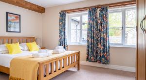 a bedroom with a bed and two windows at Bassicks at the Graythwaite Estate in Ulverston +44 photos