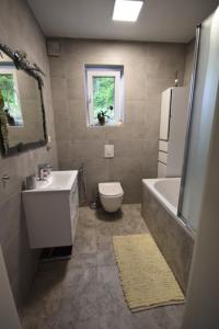 La salle de bains est pourvue d'un lavabo, de toilettes et d'une baignoire. dans l'établissement apartmaji LEJARDIN, à Škofljica